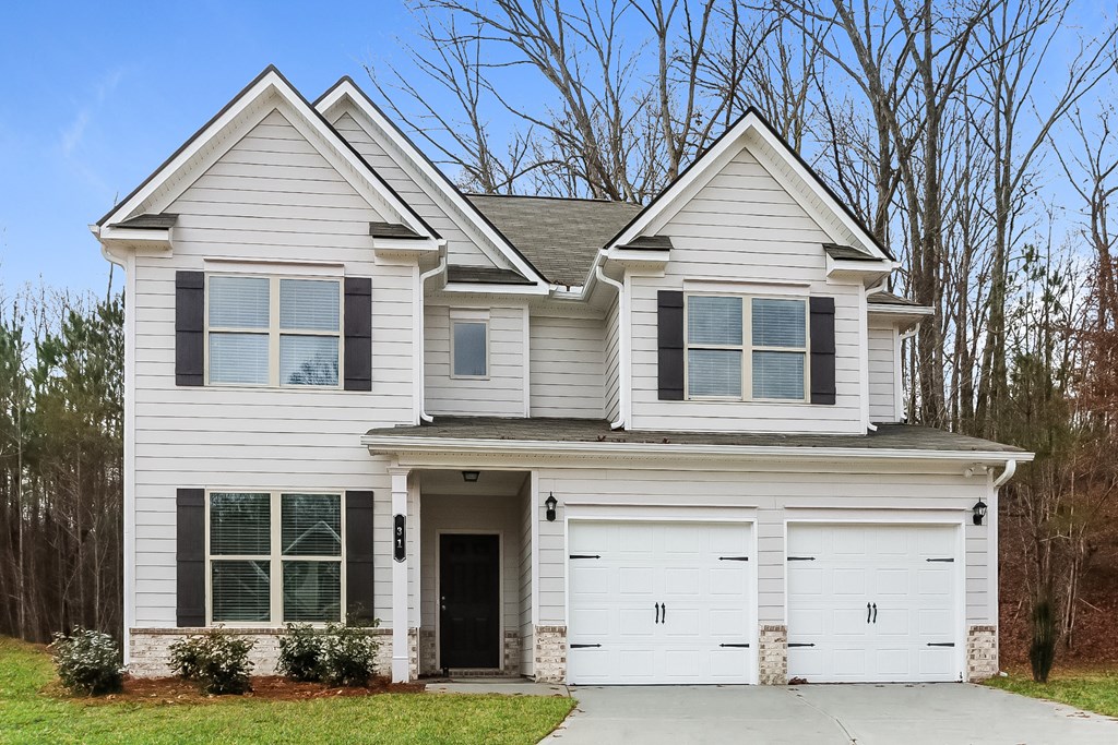 a white house with black shutters and a garage door