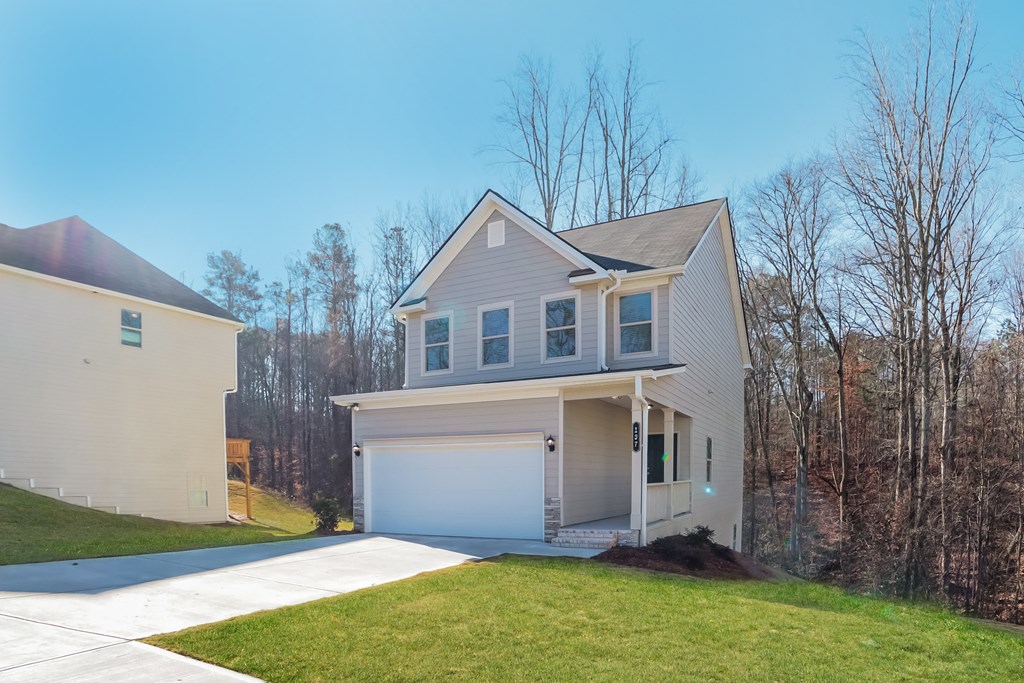 a white house with a garage door and a lawn
