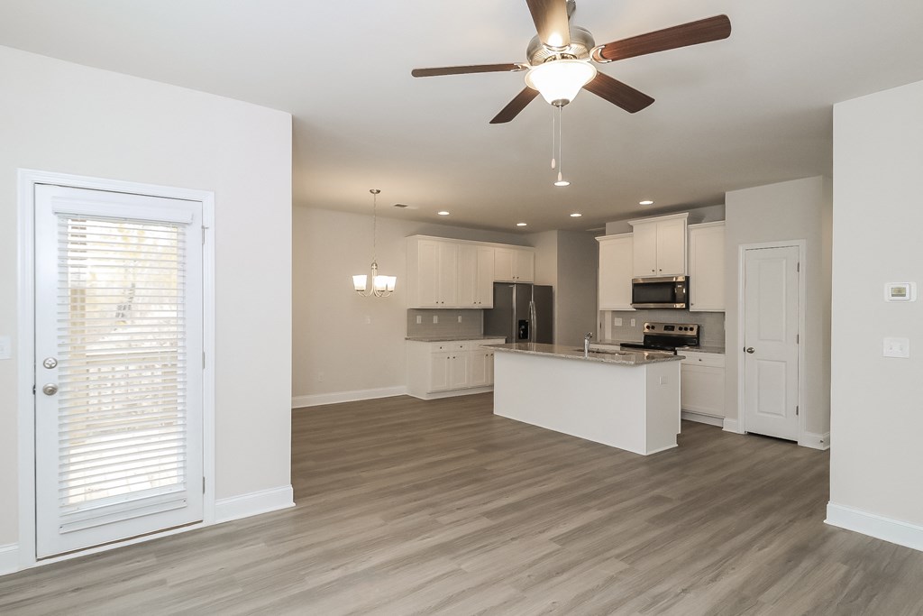 an open kitchen and living room with a ceiling fan
