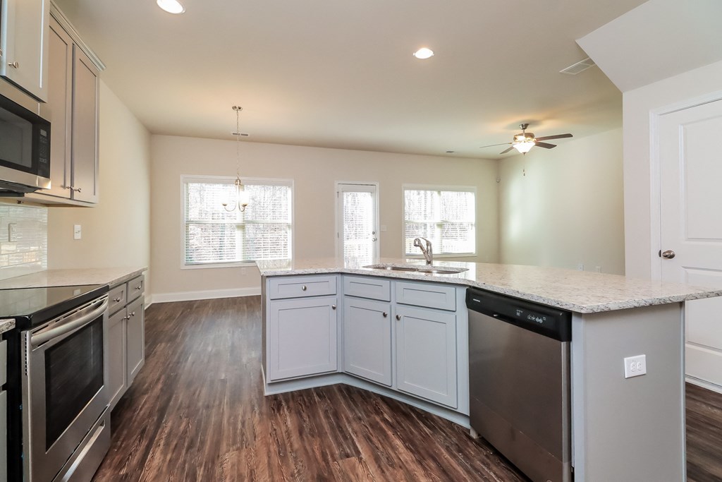 an empty kitchen with white cabinets and a counter top