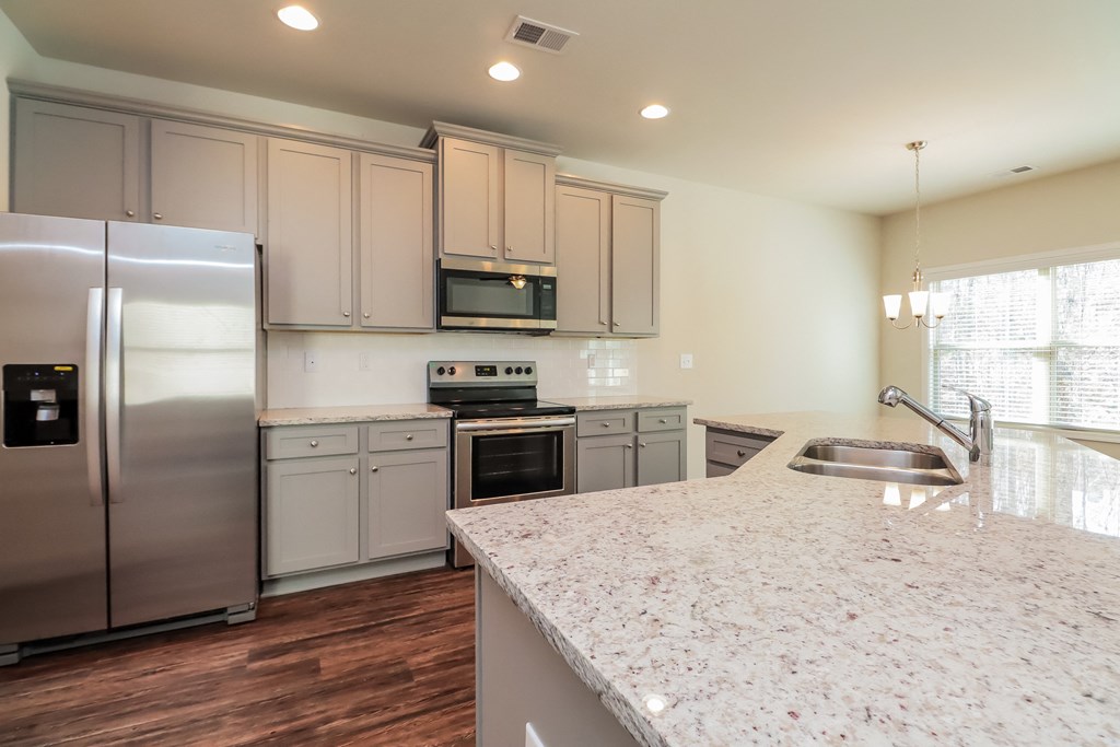 a kitchen with a marble counter top and stainless steel appliances