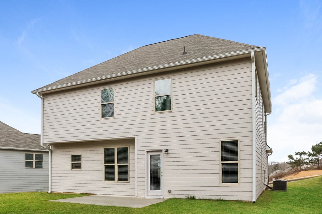 the side of a white barn with a gray roof