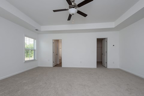 a living room with white walls and a ceiling fan