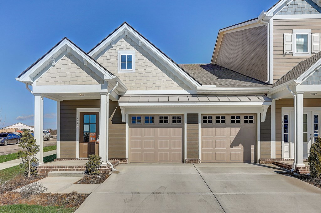A house with a grey roof and a brown garage door.