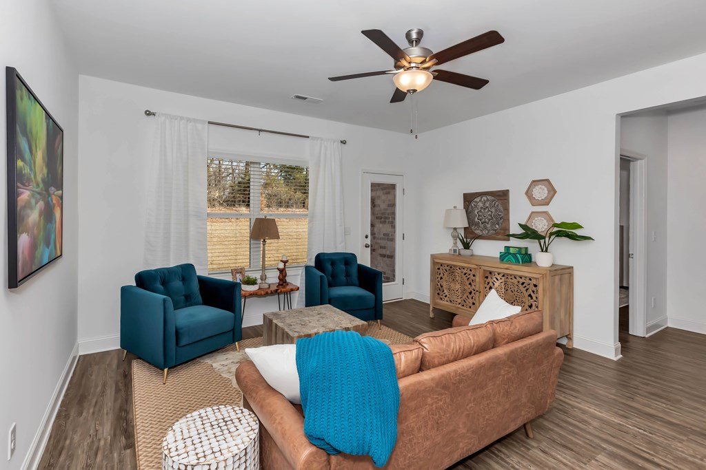 A living room with a brown couch and blue chairs.