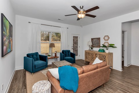 A living room with a brown couch and blue chairs.