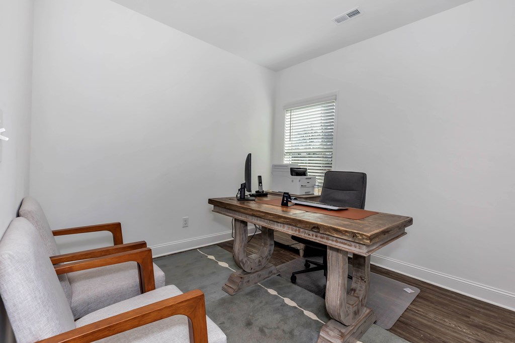 A wooden table with a laptop and a remote control on it.