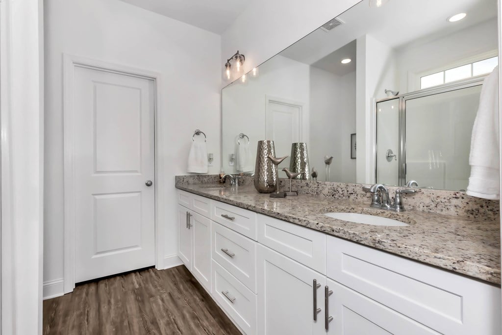 A bathroom with a white door and a marble countertop.