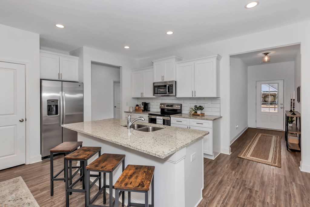 A kitchen with white cabinets and a granite countertop.