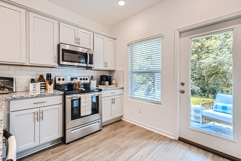 A kitchen with white cabinets and stainless steel appliances.