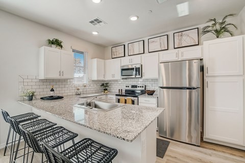 A kitchen with a granite countertop and stainless steel appliances.