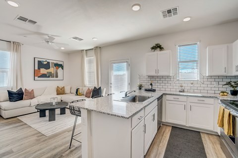 A modern kitchen with white cabinets and a large island.