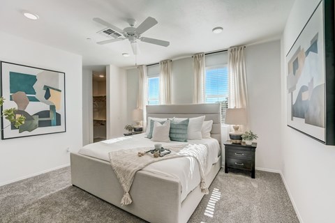 A bedroom with a large bed and a ceiling fan.