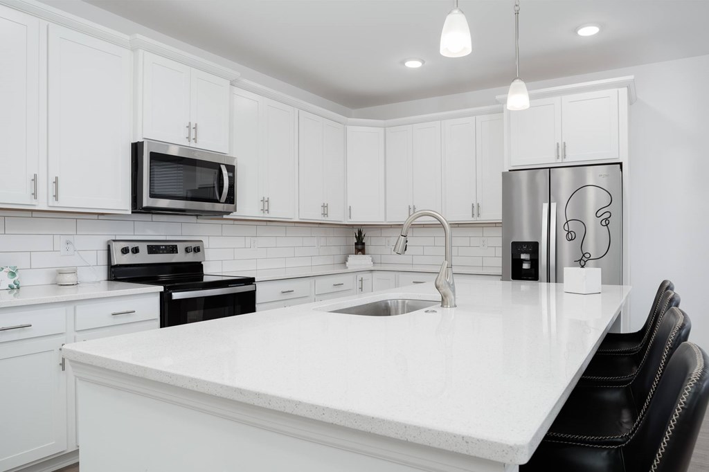 A modern kitchen with white cabinets and a white countertop.