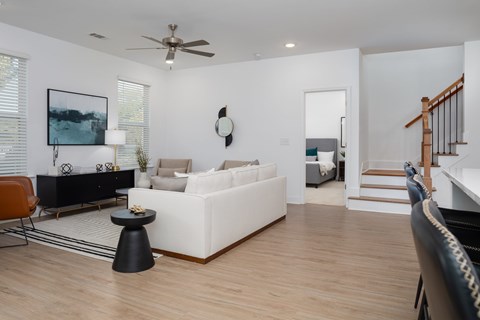 A living room with a white couch, a black coffee table, and a painting on the wall.