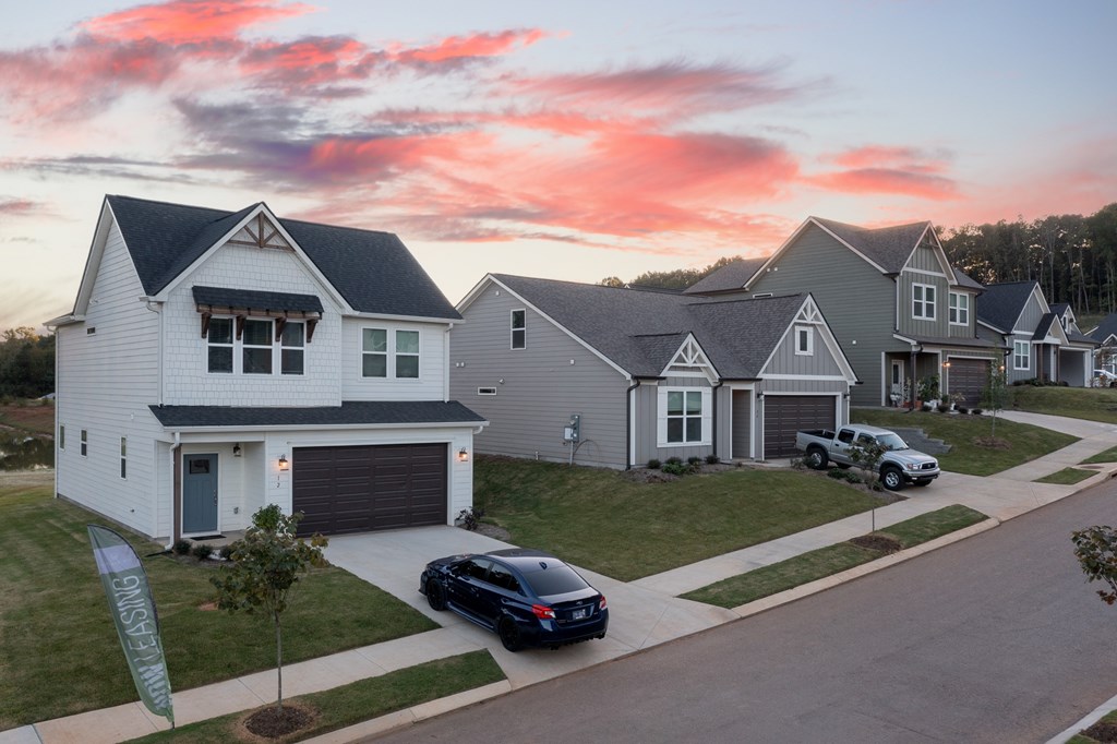 A row of houses with cars parked in front.