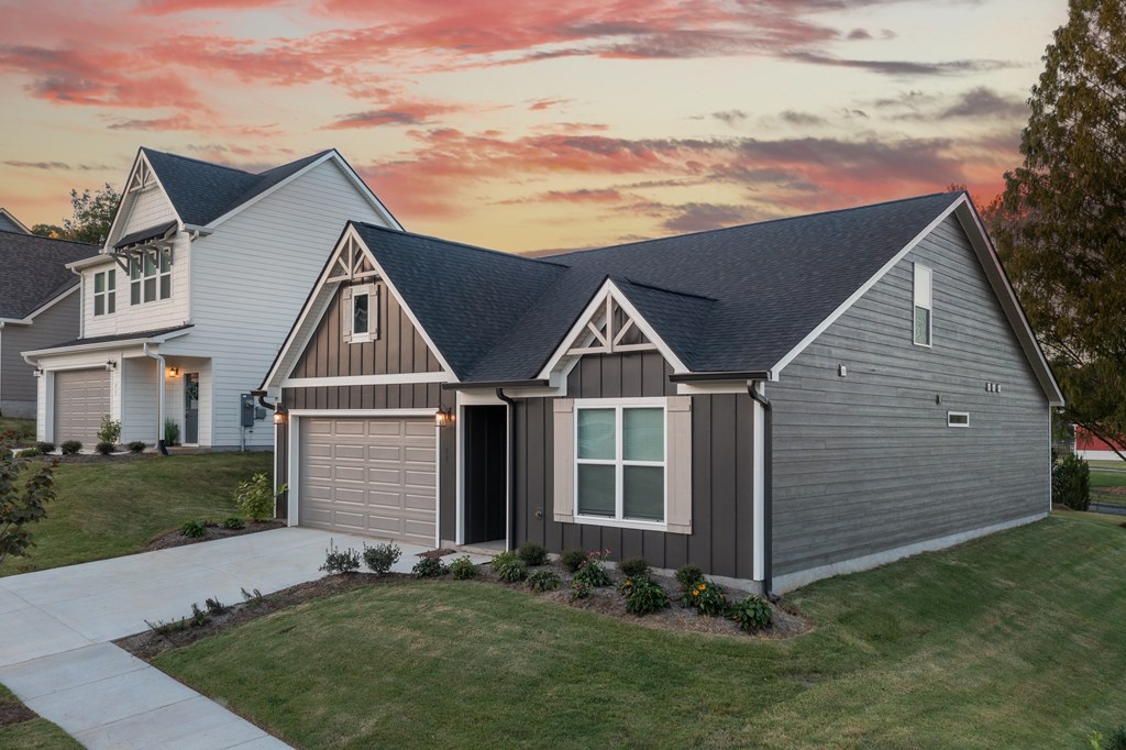 A house with a garage and a driveway in front of it.