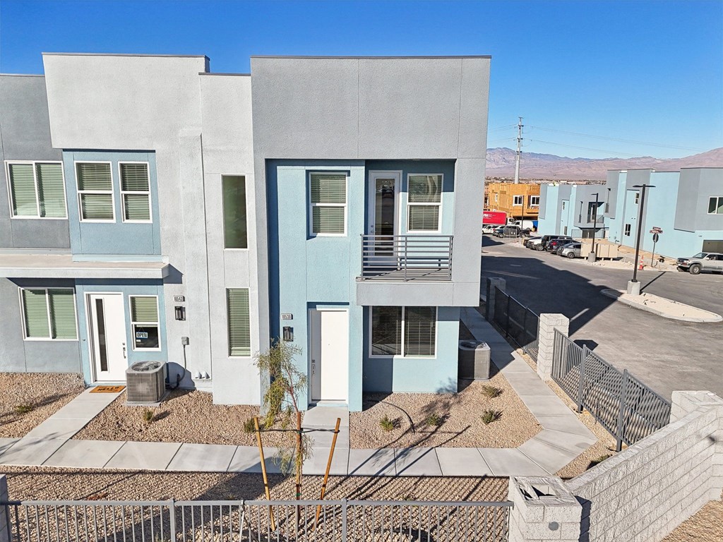 A modern two story house with a blue door and window.