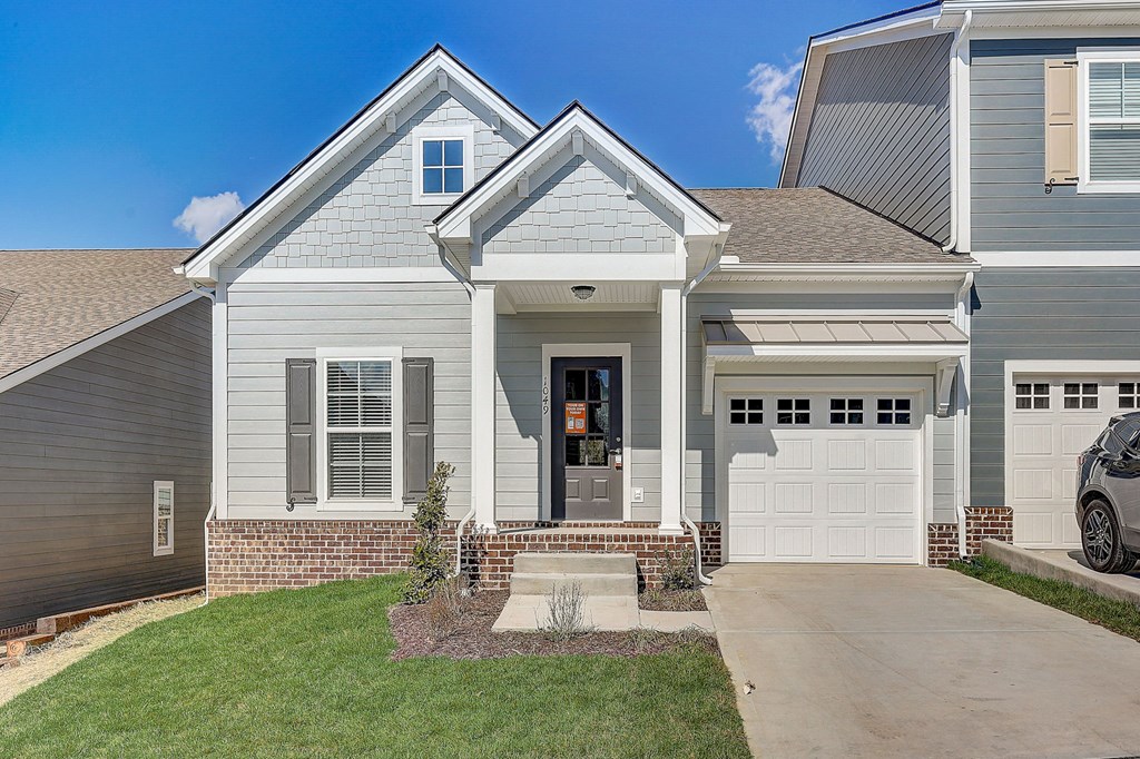 A house with a grey exterior and a white garage door.