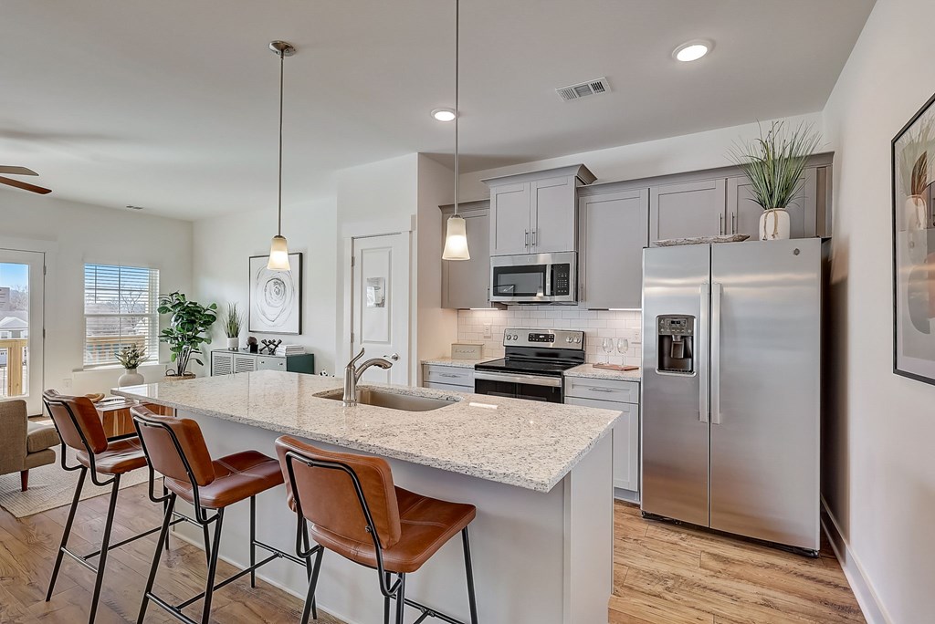 A kitchen with a white countertop and stainless steel appliances.