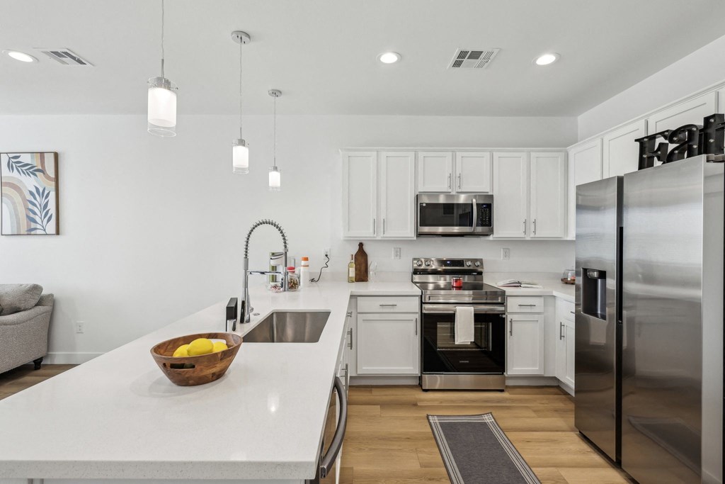 A modern kitchen with white cabinets and stainless steel appliances.