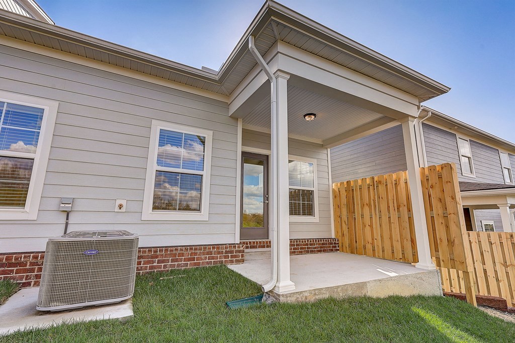A house with a covered front porch and a heat pump outside.