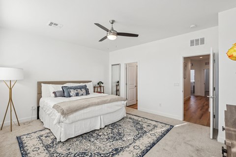 A bedroom with a large bed and a ceiling fan.