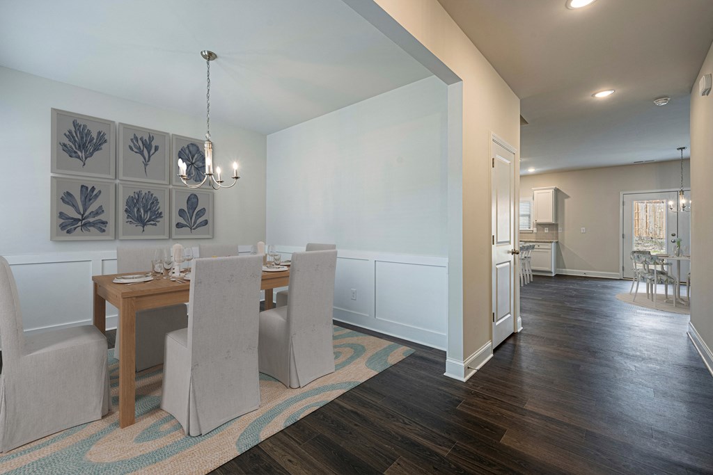 a dining room and kitchen area with a table and chairs