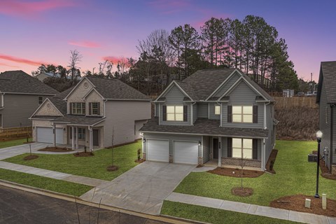 a neighborhood of homes on a street at sunset