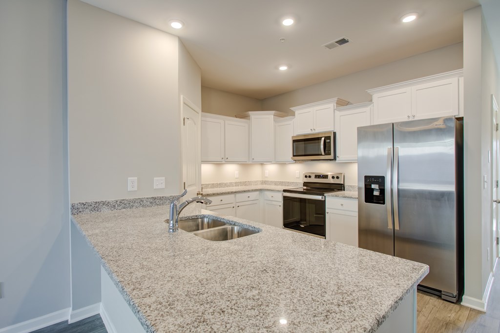 A kitchen with granite countertops and stainless steel appliances.