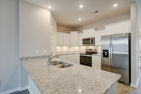 A kitchen with granite countertops and stainless steel appliances.