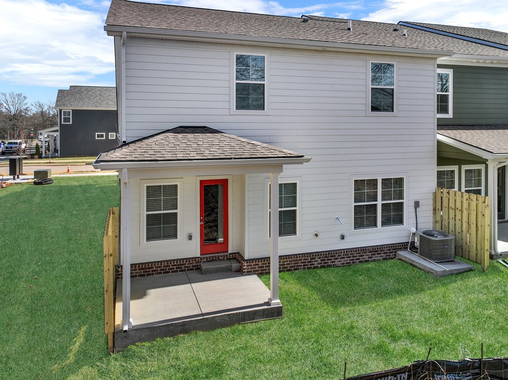 A white house with a red door and a small porch.