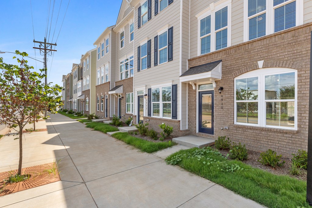 a row of town houses with a sidewalk in front of them