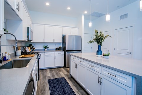 A modern kitchen with white cabinets and a dark countertop.