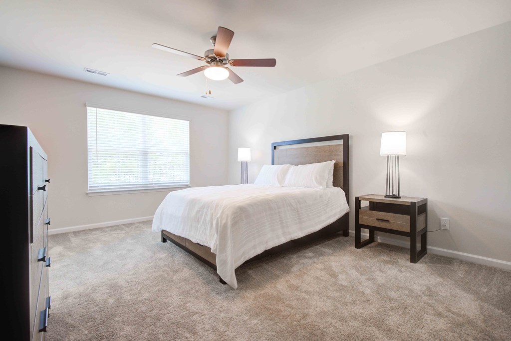 Serene master bedroom with plush carpeting and ceiling fan, creating a peaceful retreat