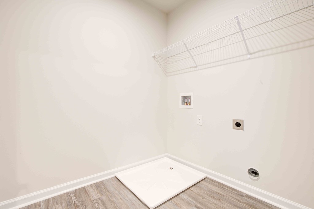 Spacious laundry room with durable flooring and convenient connections for full-size appliances