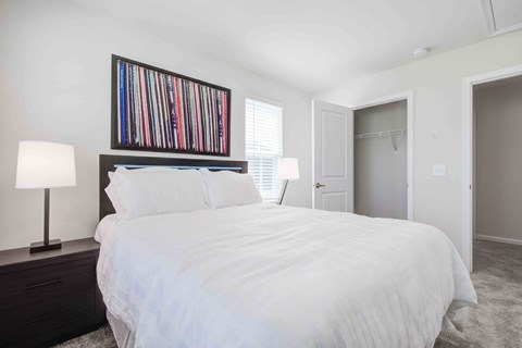 Welcoming bedroom featuring contemporary artwork, soft lighting, and neutral color palette for peaceful rest