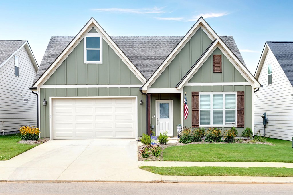 A house with a garage and a flag on the front door.