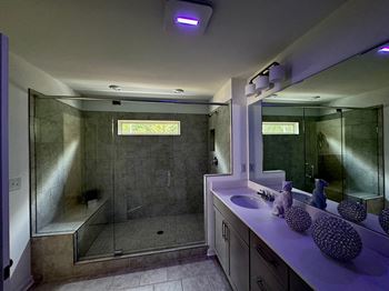 a bathroom with a sink and a shower and a mirror