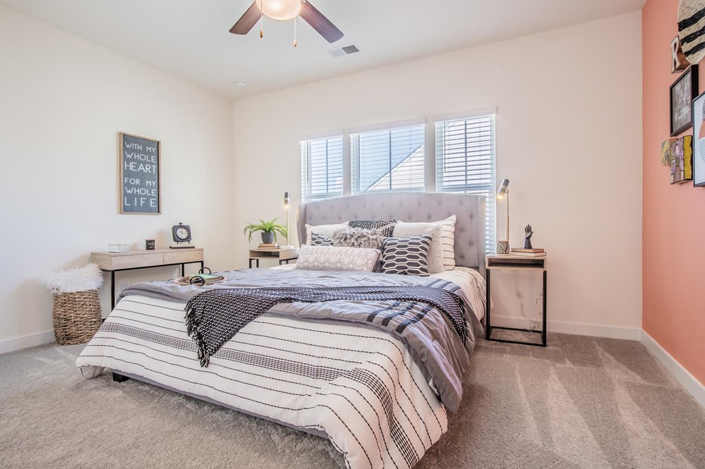 a bedroom with a bed and a ceiling fan