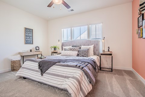 a bedroom with a bed and a ceiling fan