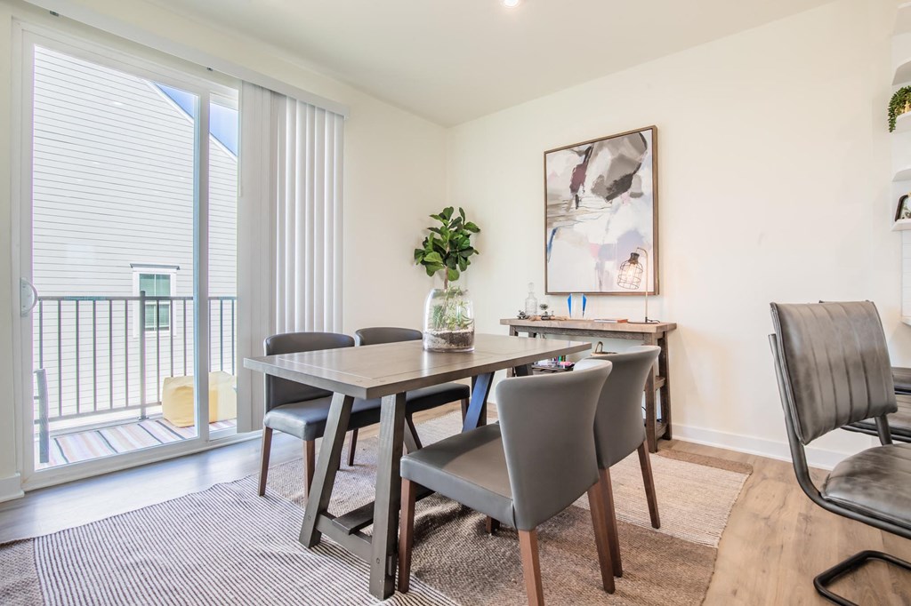 a dining room with a table and chairs and a balcony