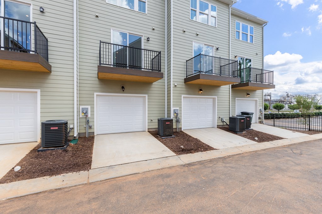 the outlook of an apartment building with two garages and a sidewalk