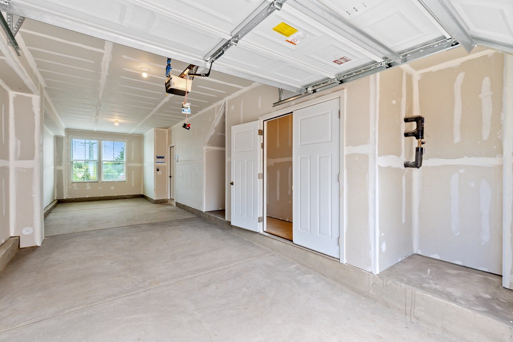 an empty room with white walls and doors and a ceiling with exposed beams