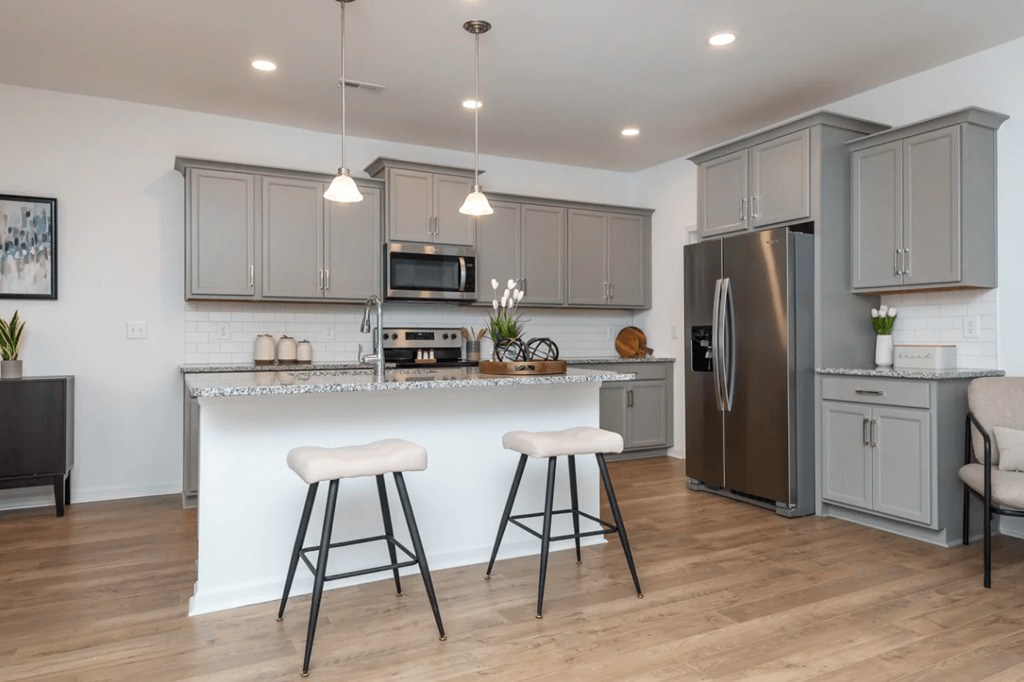 a kitchen with stainless steel appliances and a counter with two stools