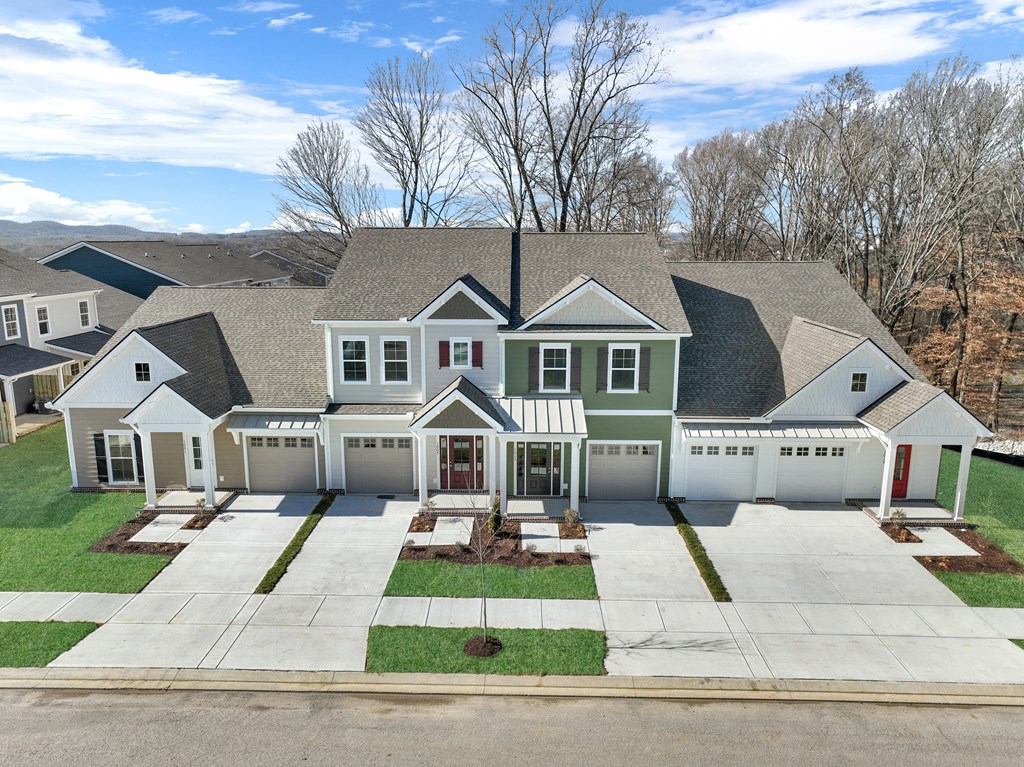A large, two-story house with a garage and a driveway.