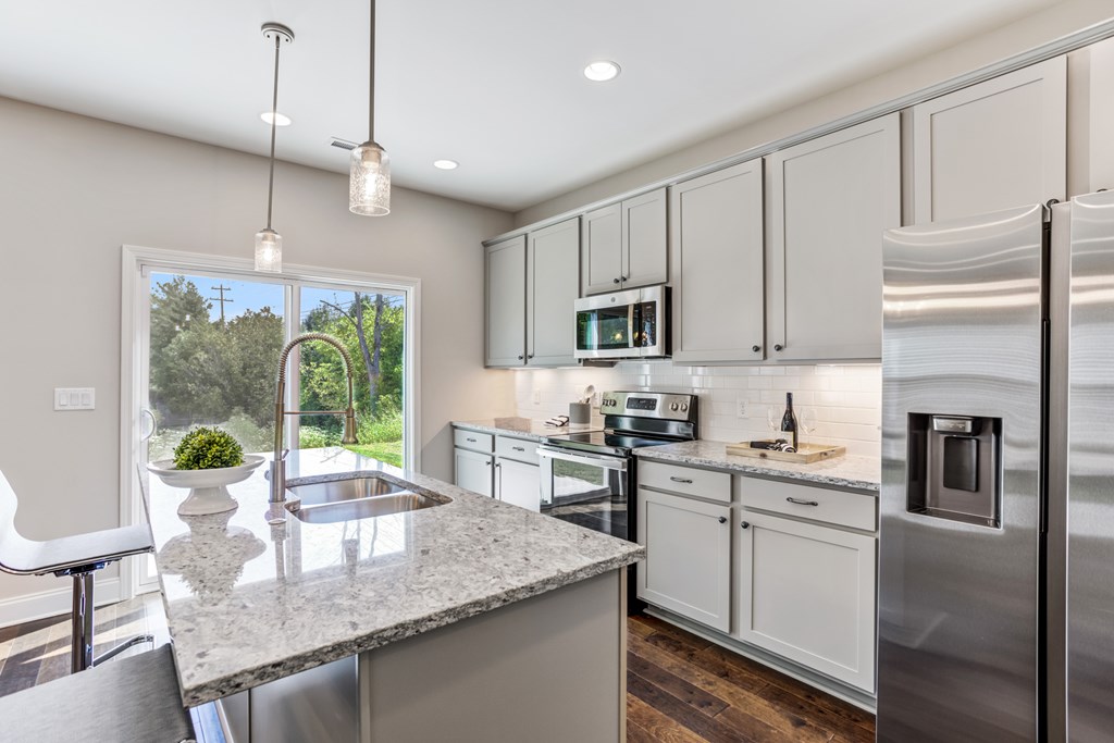 A modern kitchen with granite countertops and stainless steel appliances.