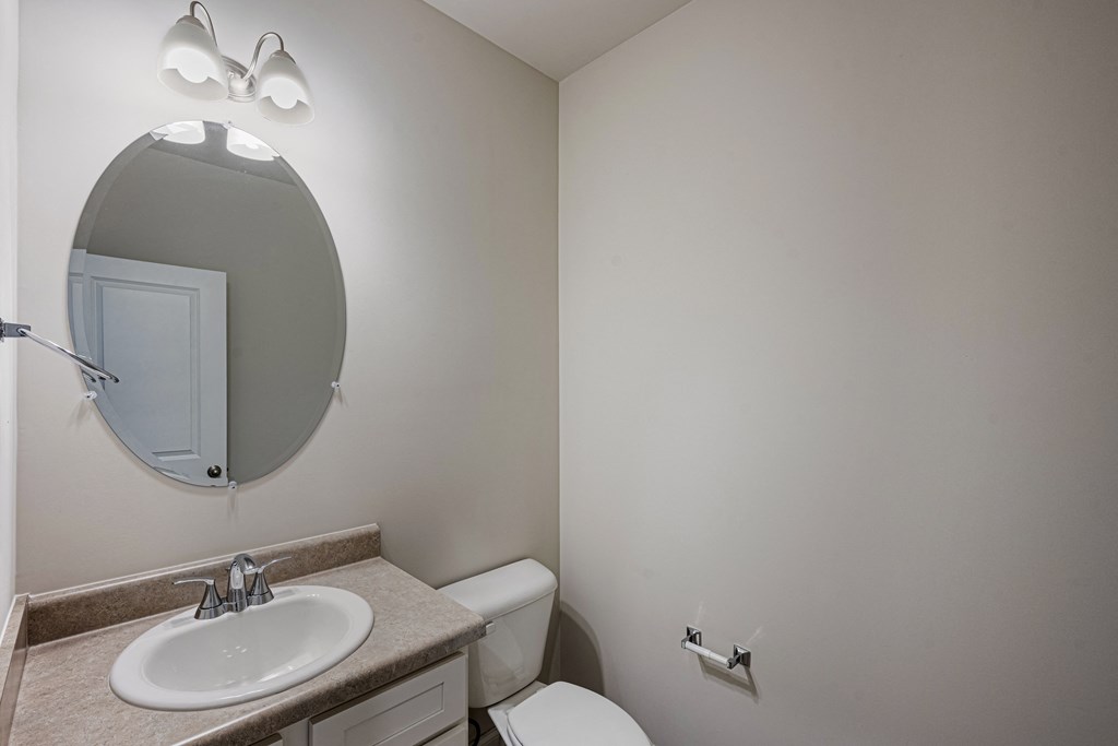 a bathroom with a mirror and a sink and a toilet