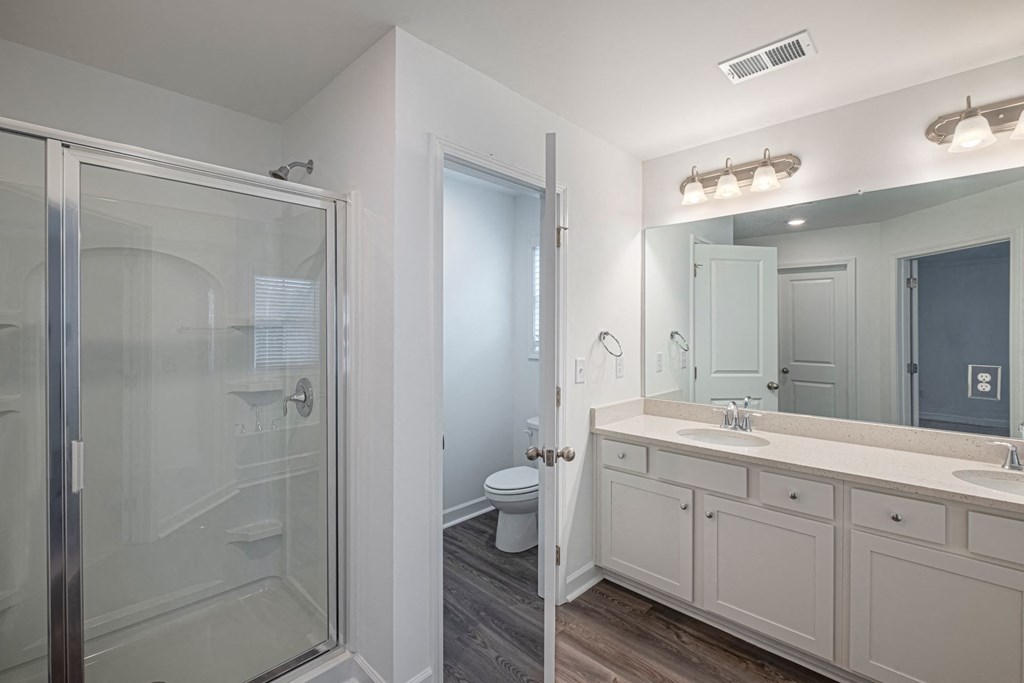 a bathroom with a shower and a sink and a mirror