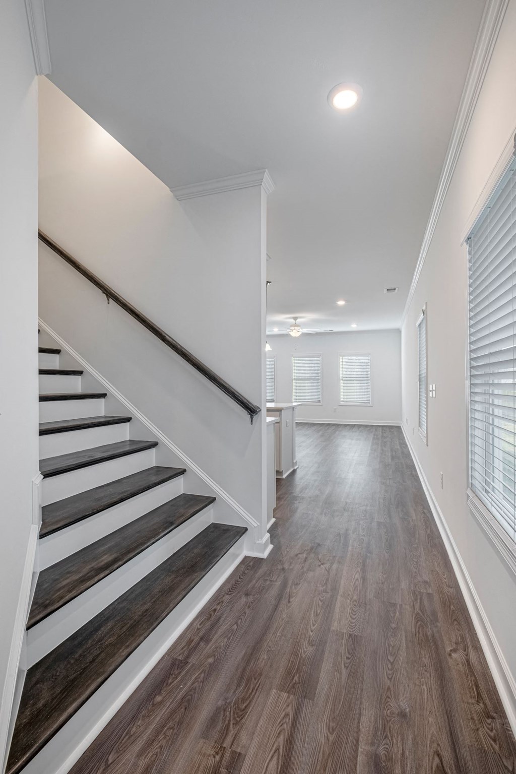 the landing of a staircase in a home with white walls and wood floors